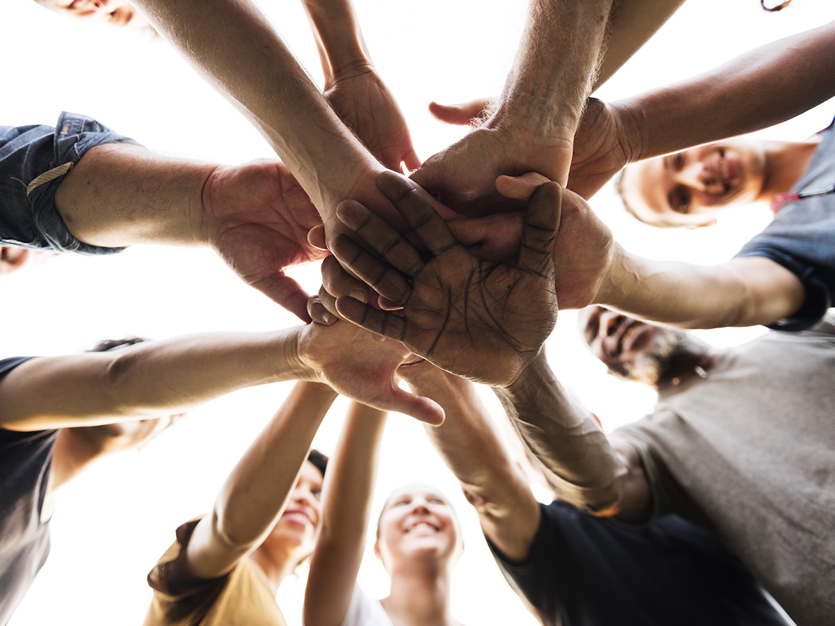 A group of hands stacked on top of each other at a team building event