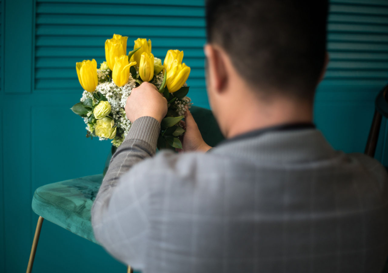 Wedding planner arranging yellow flowers for a wedding.